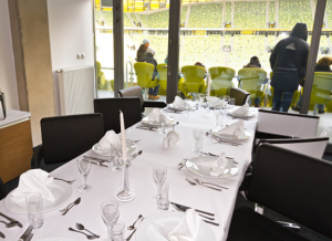 luxury skybox at stadium, dining table in foreground