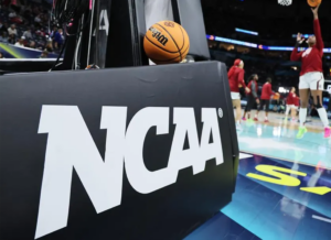 NCAA women's basketball court with the association's logo on a rubber mat protector.