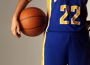 Collegiate basketball player holding a basketball. Uniform and jersey number are visible.