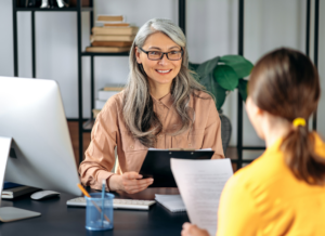 An outsourced HR director has a conversation with a client in an office setting.