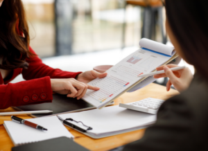 Close up of nonprofit auditors reviewing financial documents with data charts for a financial audit.