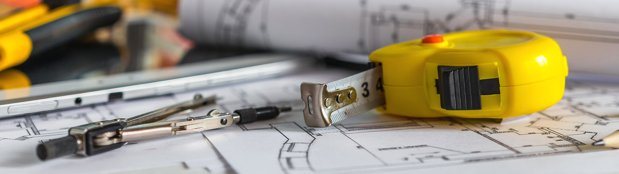 Construction measuring tape and plans.