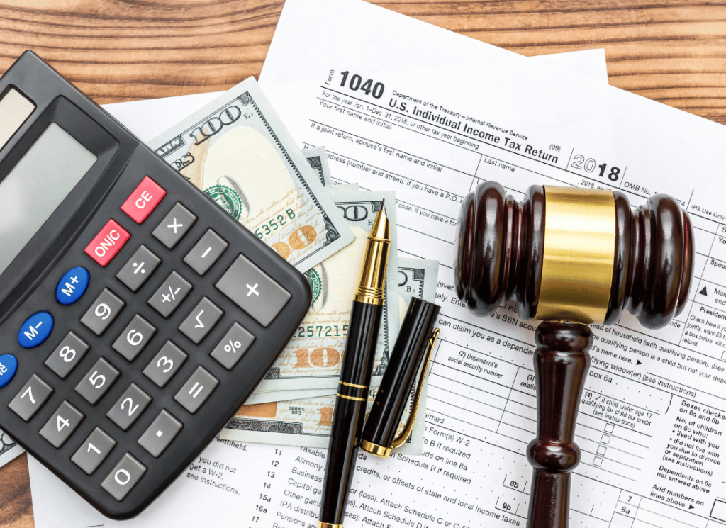 Tax documents, a gavel, calculator, and cash on a desk representing the legal and financial implications of the Tax Relief for American Families and Workers Act of 2024.