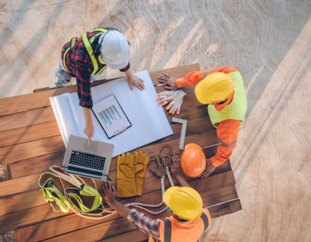 Team of engineer and architects working, meeting, discussing,designing, planning, measuring layout of building blueprints at construction site.