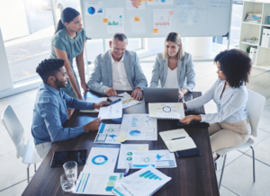 A team of nonprofit professionals discussing financial reports and KPIs around a conference table in a modern office.